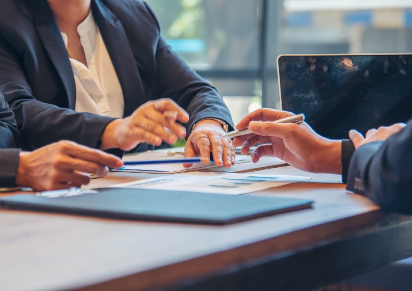 hands pointing at business documents